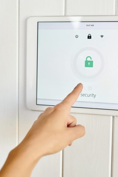 a-hand-pointing-at-panel-of-home-security-appliance-e1624415881487